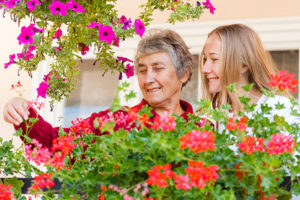 alzheimers lady with caregiver and flowers