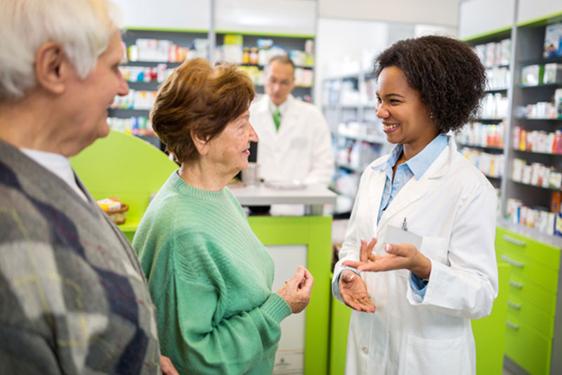 senior couple talking to pharmacist