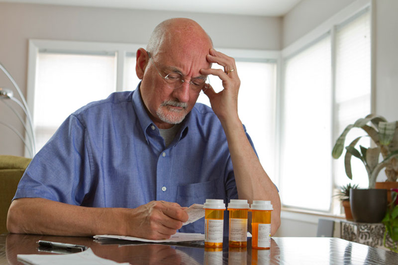 An older man looks through his prescriptions wondering which medications cause falls.